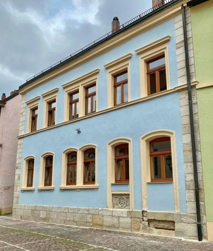 Blau gestrichener Altbau mit Sandsteinfenstern