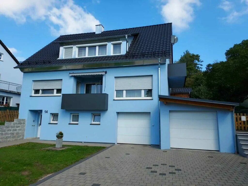 Blaue Fassade an einem Wohnhaus mit Garage