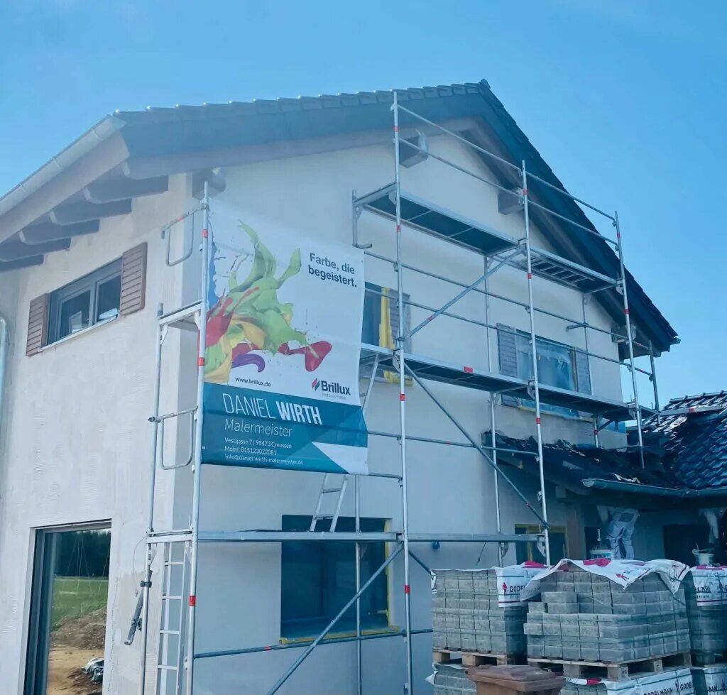 Gerüst mit Firmenplane an einem Neubau