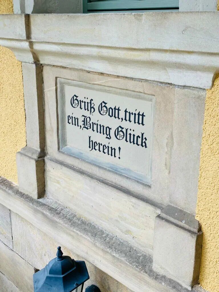 Hausspruch auf einer Sandsteintafel an der Fassade
