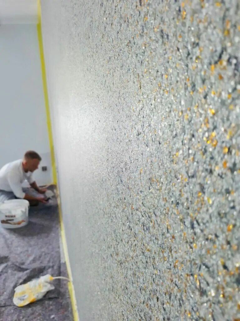 Maler bei der Arbeit an einer Wand in Spachteltechnik